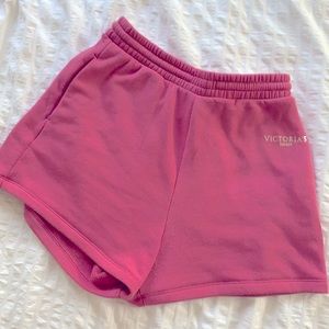 Victoria’s Secret pink shorts with gold logo on the right